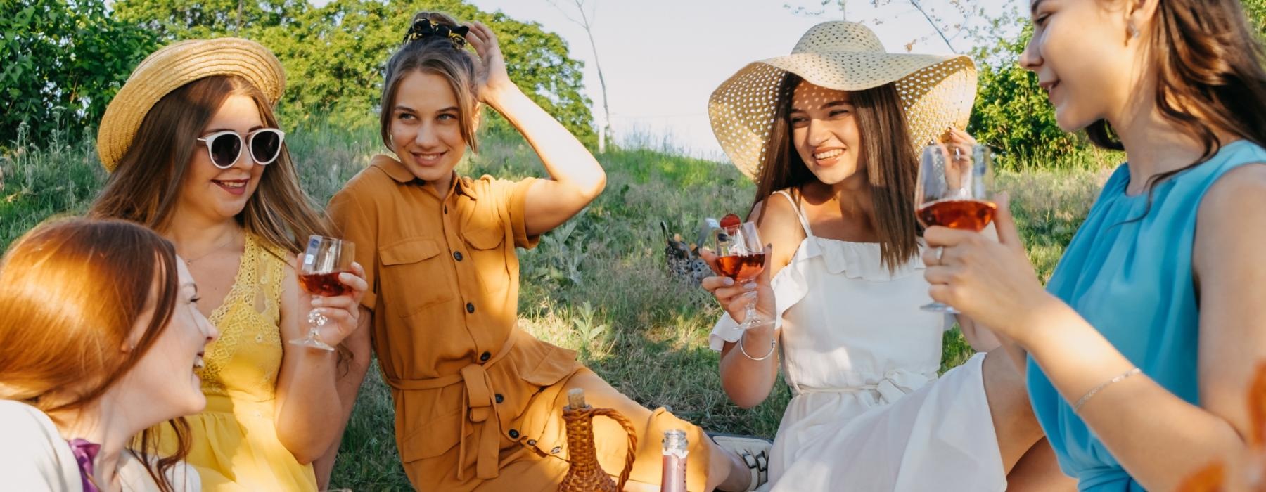 Lifestyle photo of a group of women sitting outside smiling and drinking