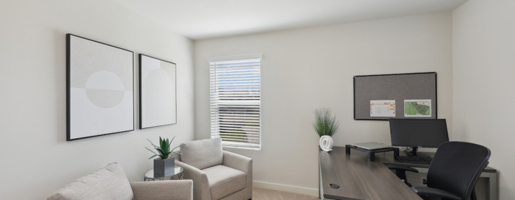 Home office with a desk and sitting chairs inside a unit at Canvas at Mt. Juliet